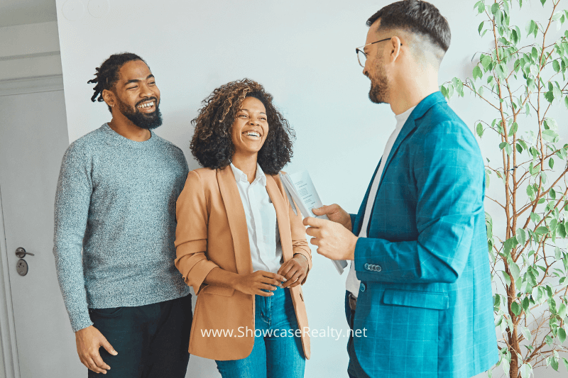 Young happy couple, accompanied by their trusted agent, explores a promising Charlotte NC property on the market.