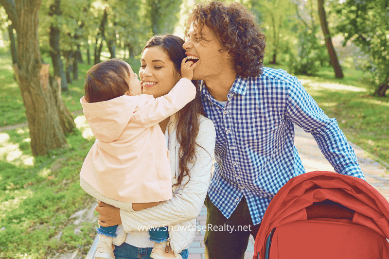 Family walking in the park, representing the family-friendly neighborhoods promoted by Nancy Braun Real Estate.