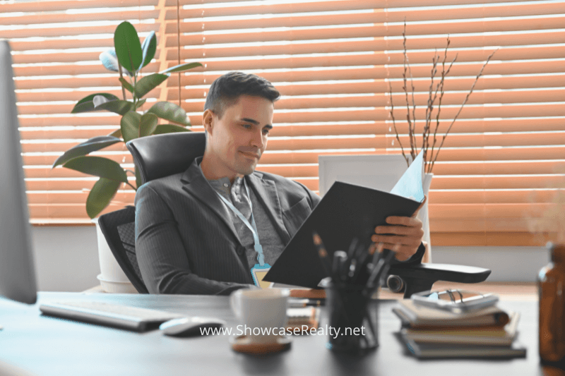 An experienced real estate agent carefully reviews property report documents for homes available in Charlotte, NC.