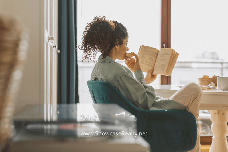 Comfortable indoor space in a Charlotte North Carolina home for sale, featuring a woman reading during breakfast.
