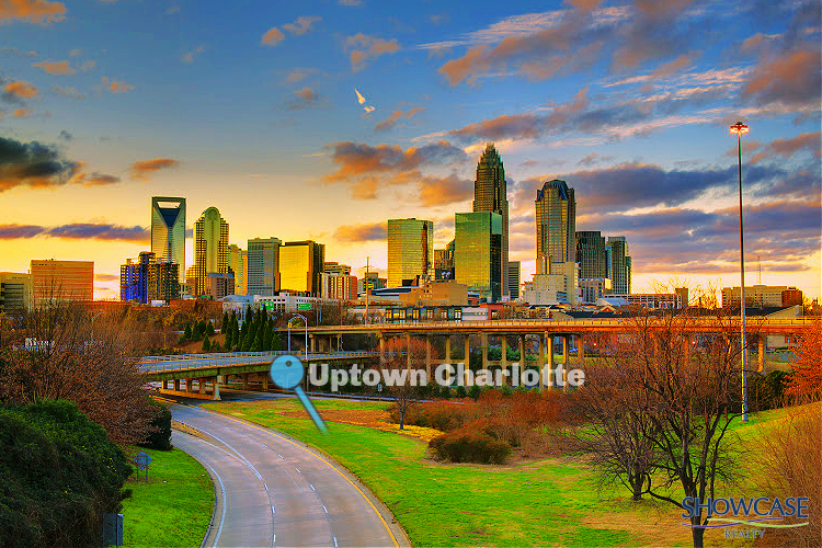 Panoramic view of Uptown Charlotte, North Carolina, at sunset, with the skyline featuring prominent skyscrapers like the Duke Energy Center and the Bank of America building. The golden light reflects off the buildings as a highway curves through the green landscape in the foreground. A light blue map marker points to the label 'Uptown Charlotte,' emphasizing the city's vibrant urban scene...