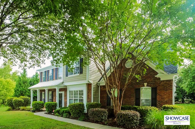 Classic Brick Home Ballantyne Charlotte NC Real Estate Charming two-story brick home with lush landscaping and mature trees in the Ballantyne Charlotte NC community. A picturesque example of Charlotte NC real estate, ideal for families looking for serene suburban living within Ballantyne. Listed by Showcase Realty Ballantyne South Charlotte.