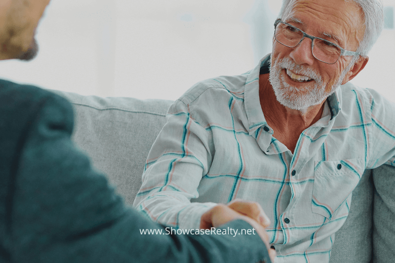 An older man smiling and shaking hands with a real estate agent, symbolizing trust and professionalism in Charlotte NC real estate services. This image reflects the connection and commitment to clients seeking Charlotte NC homes for sale and highlights Showcase Realty's dedication to customer satisfaction.
