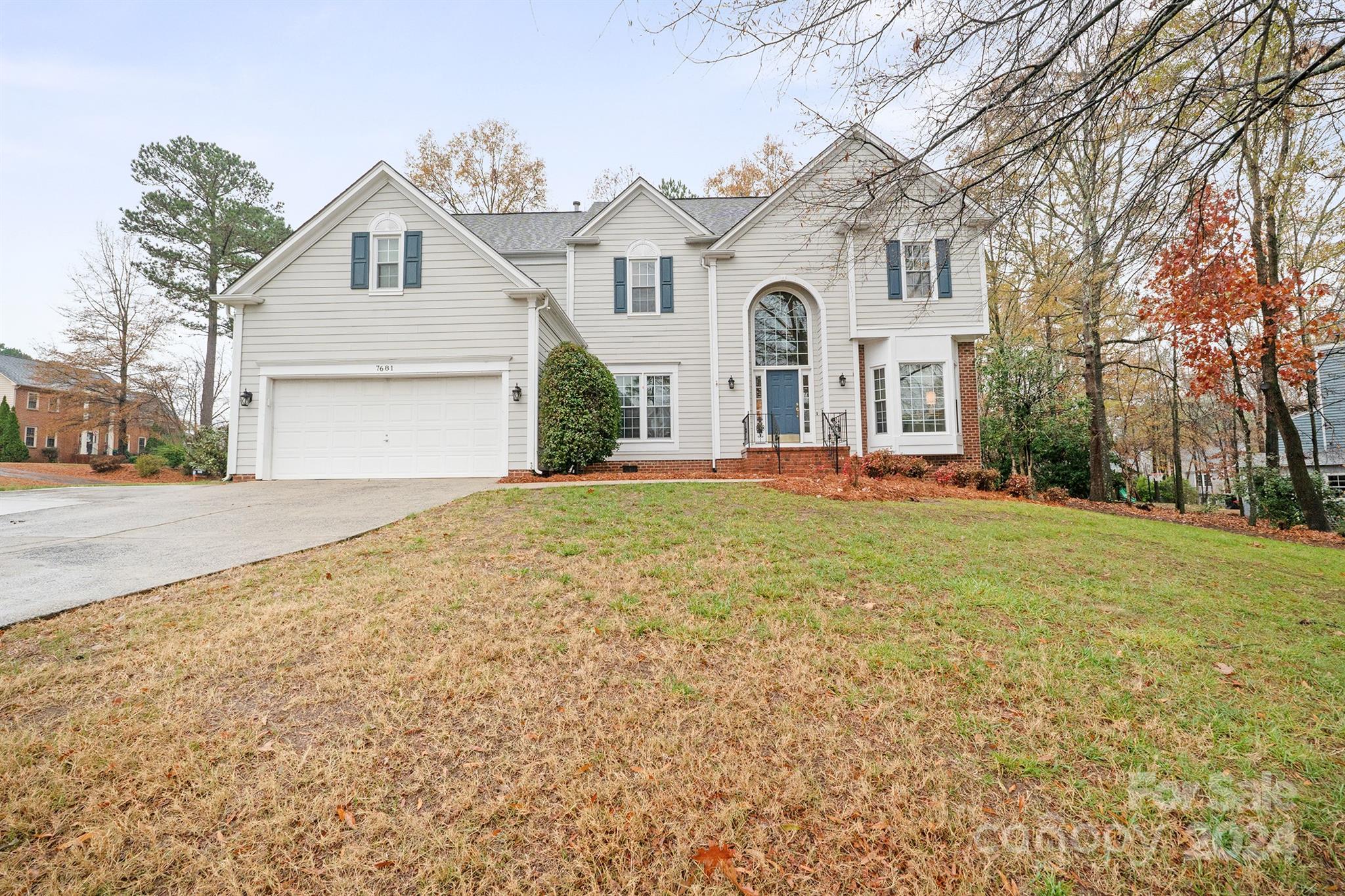 Stunning two-story home at 7681 Orchard Park Cir in Harrisburg, NC, with a spacious front yard, double garage, and classic architectural design in a quiet suburban neighborhood...
