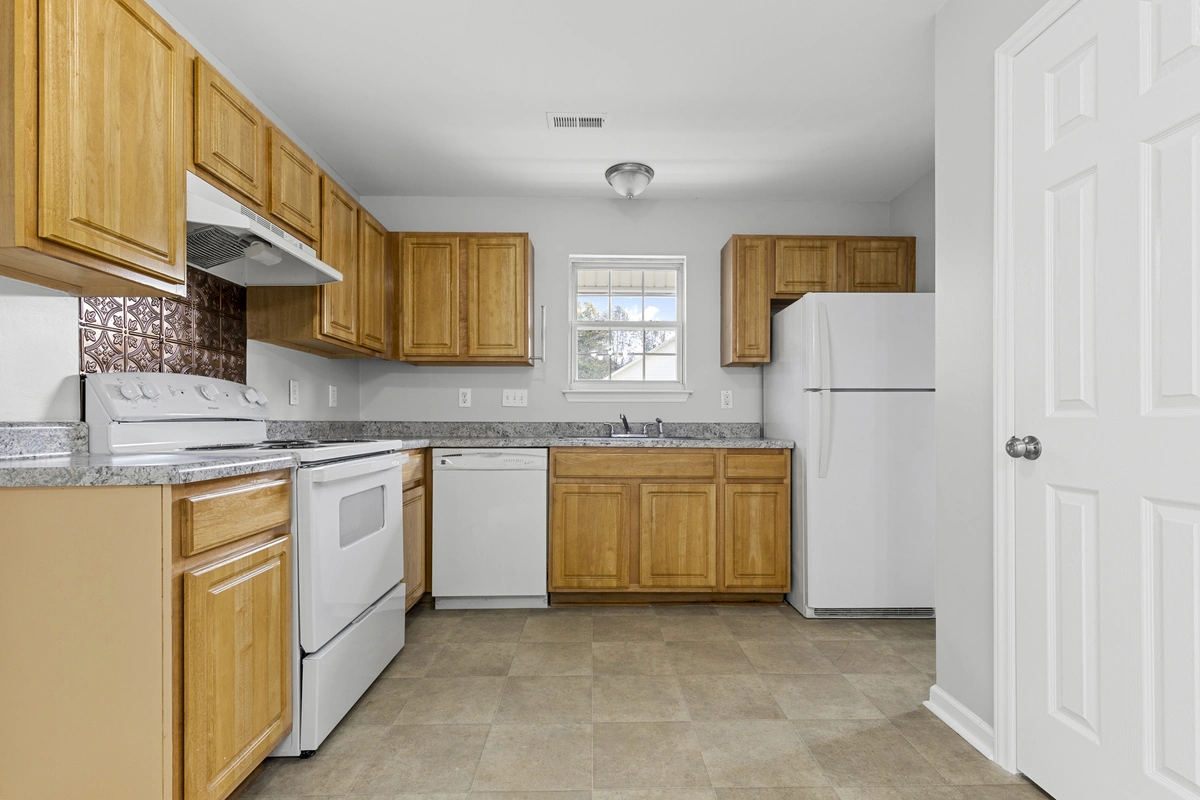 Spacious living room in a Charlotte, NC home for sale at 3703 Silver Ore Ln, showcasing fresh gray walls, plush carpet, and a cozy fireplace...