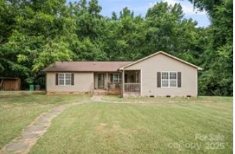 Beautiful front yard of 1925 Dunavant Street, Charlotte, NC, with a well-maintained lawn, a charming pathway, and a picturesque view of the surrounding greenery...