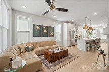 Modern living room in a luxury Charlotte townhome at 1925 Dunavant St. Features an open floor plan, stylish decor, and natural light flowing through multiple windows...
