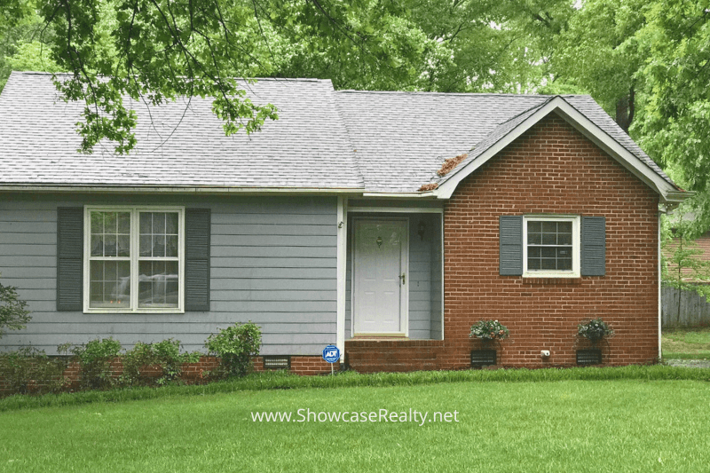 Front view of a small, charming brick-and-siding home with a manicured lawn, representing affordable Charlotte NC real estate options for first-time buyers through Showcase Realty and the Charlotte NC home selling market.