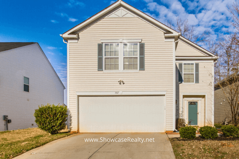 Front exterior of a two-story beige home with a double garage in the Kingstree neighborhood, ideal for buyers exploring investment opportunities. This home is featured in Charlotte NC real estate listings and represents smart Charlotte NC home buying options with Showcase Realty.