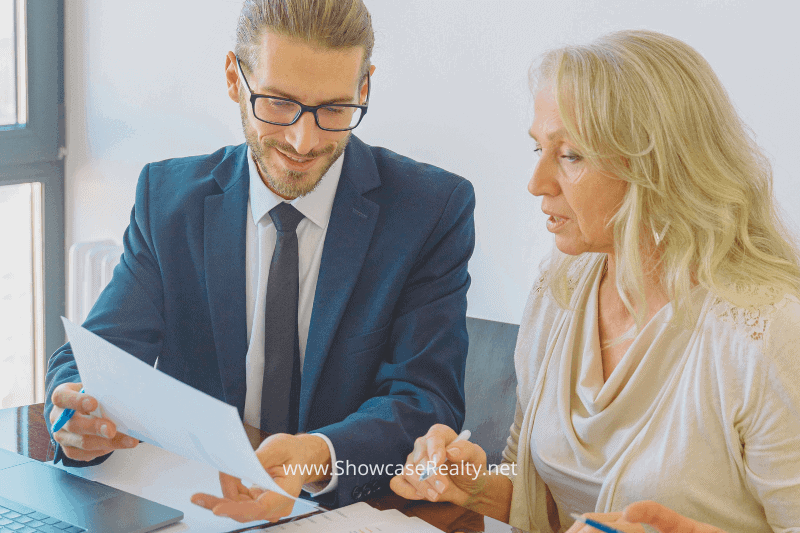 A real estate professional reviews financing documents with a female client, providing expert advice and clarity. This image highlights the personal guidance offered by Showcase Realty for Charlotte NC home buying and investment support in the Charlotte NC real estate market.