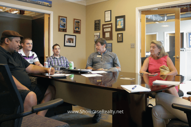 Showcase Realty team gathered around a conference table during a strategy meeting — representing teamwork and expert guidance in Charlotte NC real estate and home buying services.